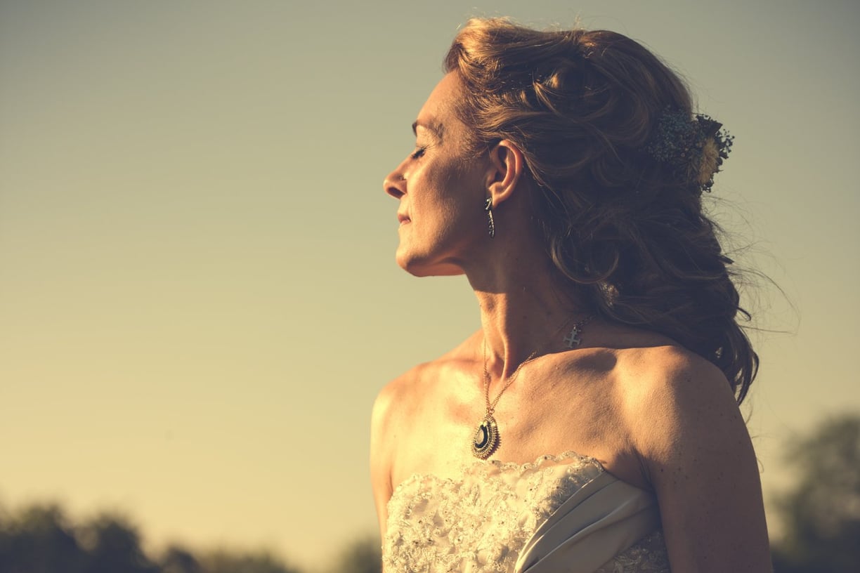 a woman in a white dress standing in a field