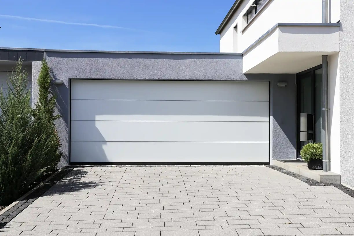 a garage door with a white garage door and a brick wall