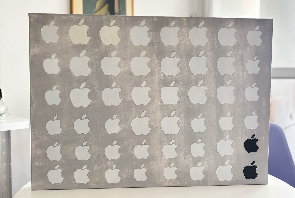 foto da arte contemporânea composta de uma tela de 70x50 cm pintada em cinza claro coberta por 48 adesivos da apple.