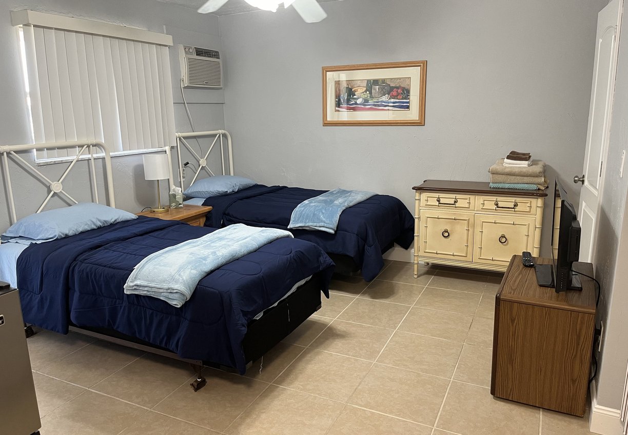 a bedroom with two beds and a television