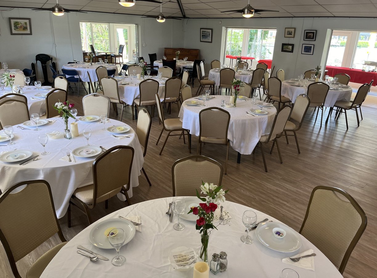 a table setting with white tablecloth and chairs