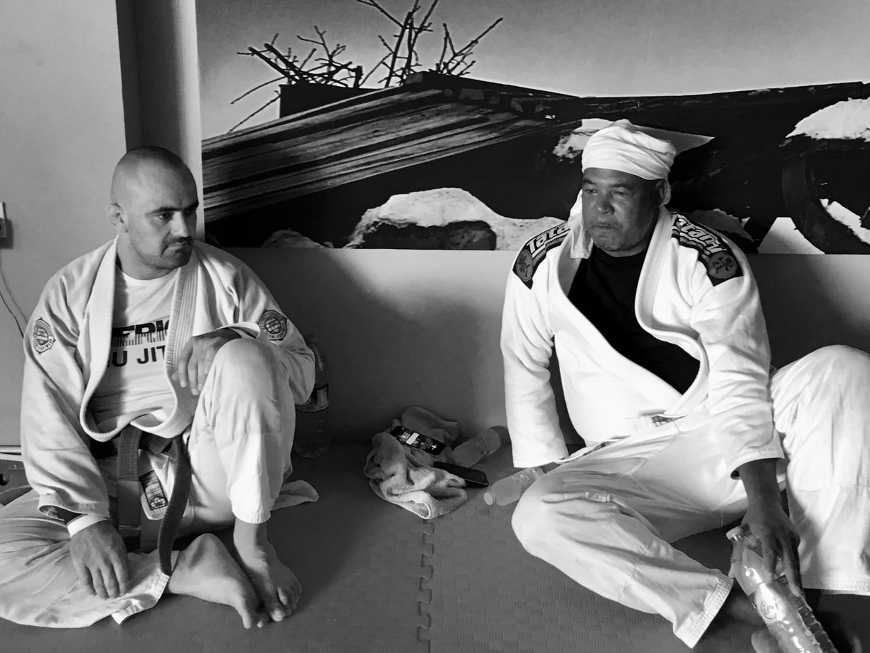 two men sitting on the mat