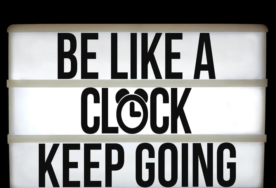 a sign that says be like a clock keep going