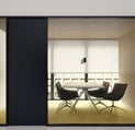 Sala de reuniones moderna con mamparas correderas de cristal y mobiliario minimalista