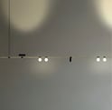 Sistema de iluminación modular E22 SYSTEM con focos orientables integrados en estructura lineal suspendida
