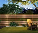 Cerramiento exterior con lamas verticales en madera para jardín residencial con privacidad y diseño natural