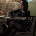 Singer Songwriter Angie Jean playing acoustic guitar