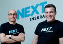 next insurance two men standing next to each other in front of a next - to - sign