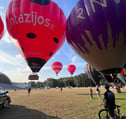 a man standing in front of a group of hot air balloons