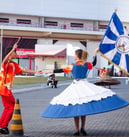 uma porta bandeira e um mestre sala ensaiando, a porta bandeira com o pavilhao da Filhos da Santa