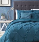 a bed with a blue comforter and pillows