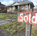 SOLD sign in front of a distressed home