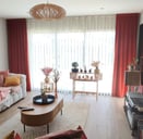 Double rideaux en velours terracotta de la maison Designers Guild et voilages avec tête plis plats