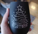 Schwarzes Glas, in der Hand gehalten, mit einem Weihnachtsbaum und Geschenke Motiv