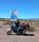 a woman standing next to a motorcycle with a map of the world