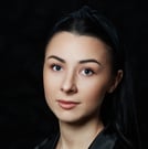 a woman in a black jacket and a necklace