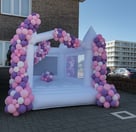 Wit springkussen met kleurrijke ballonnen, ideaal voor kinderfeestjes en evenementen.