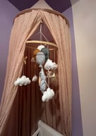 Installation d’un ciel de lit avec un mobile sur le thème éléphant