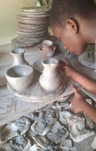 une jeune fille des ateliers créatifs fabrique des pots en poterie