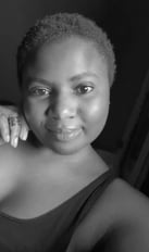 a woman with a hand on her jaw smiling at he camera