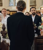 a bride and groom walking down the aisle of a church