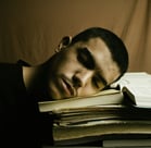 jeune homme fatigué, la tête sur ses livres