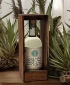 Botella de lu mezcal tepextate silvestre con fondo blanco y plantas de mezcal, botella caja madera