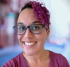a woman with glasses and a purple shirt
