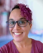 a woman with glasses and a purple shirt
