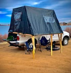 A truck with a fold-out overlanding tent on it's bed