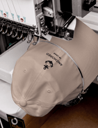 a beige cap being embroidered with anchor design