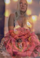 Maryann seated in reflection within a rose, symbolizing soul alchemy, feminine healing, and light