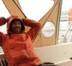 arctos guide sitting on a boat smiling | ski and sail in Norway