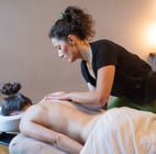 Masseuse qui fait un décollement d'omoplate avec femme allongée sur le ventre