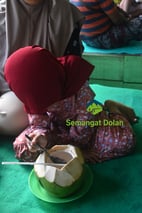 menikmati kelapa muda di pantai watu pecak