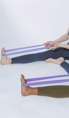 Yoga using bands to stretch legs and feet