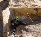 a person climbing a rock face on a rock face