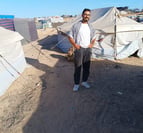 a man standing in front of a tent with tents and tents