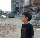 a young boy standing in front of a building