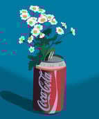 Une canette de coca qui sert de vase où sont des marguerites