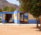 Our studio blue building with a mountain in the background