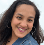 a woman with a blue jean jean jacket and earrings