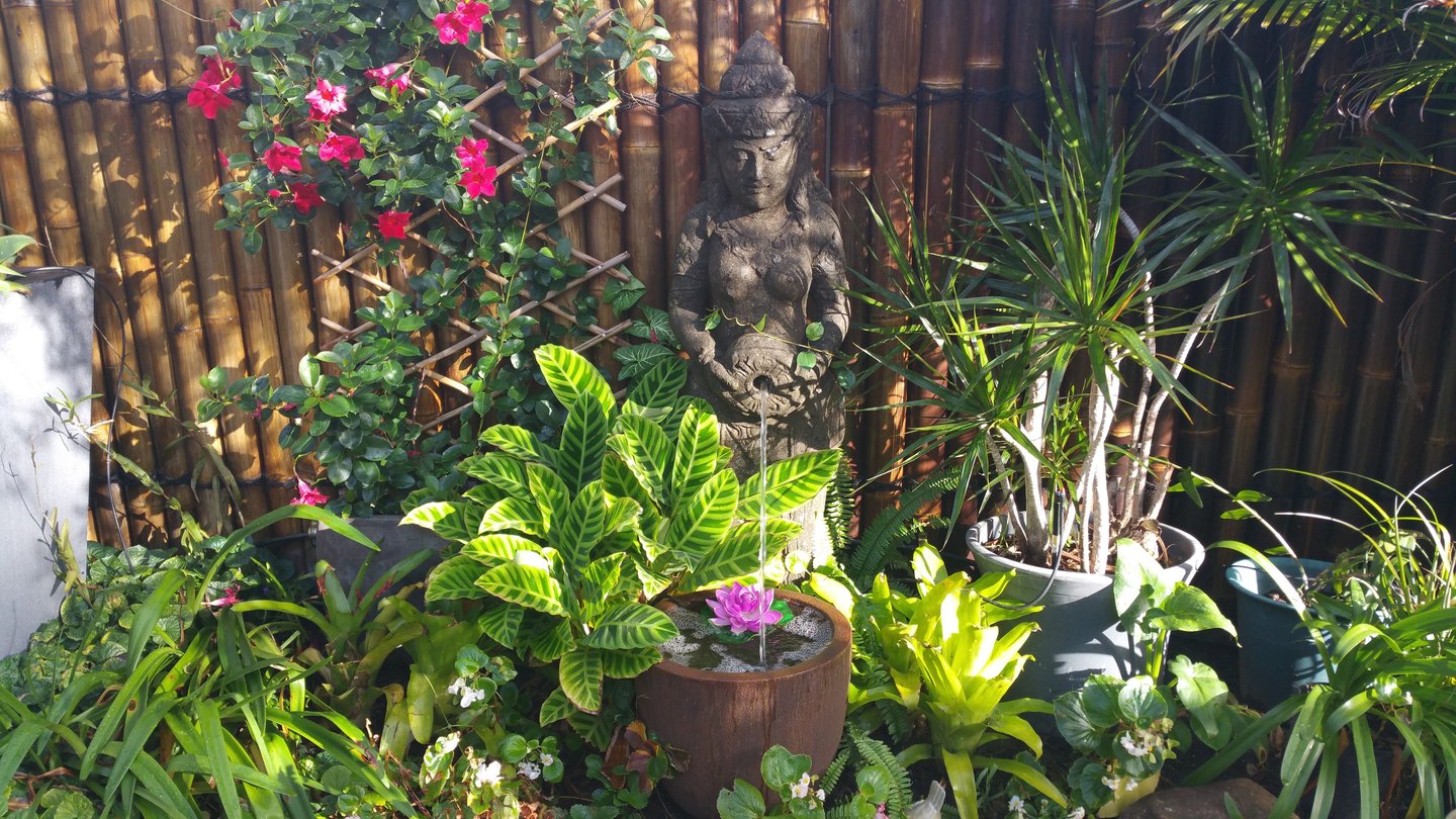 Decorative goddess statue in the garden at Marché Nude Stay.