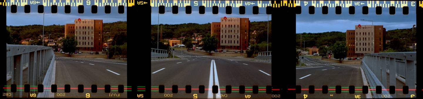 Composed photo of a bridge leading to a building, dark hill in the background