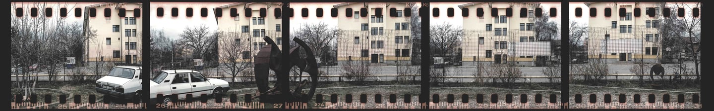 Composed photo of a city street with parked communist car and buildings, film strip