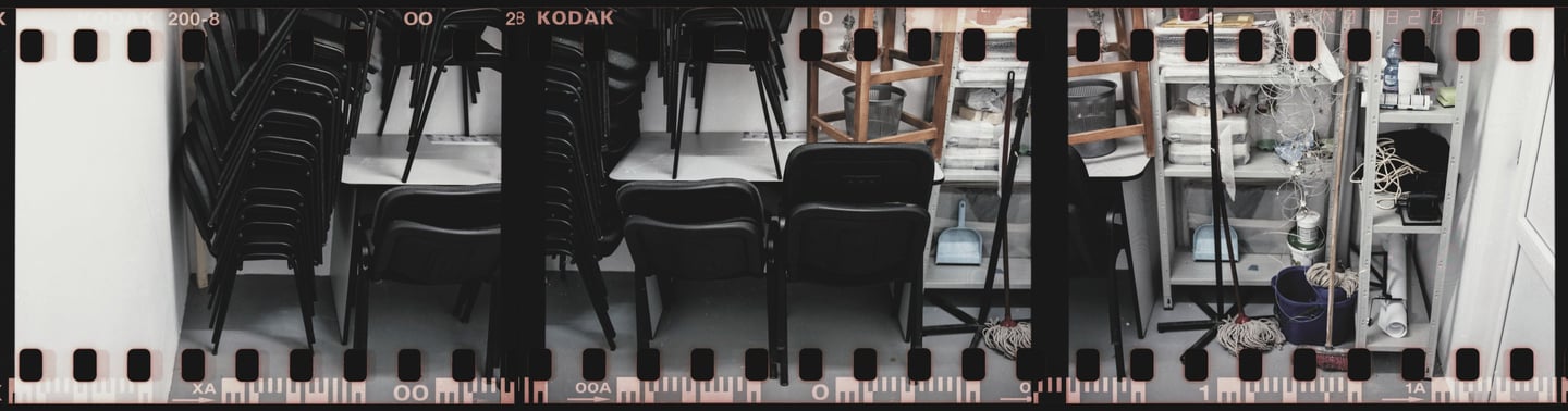 Composed photo of a storage room with stacked chairs and varied items 