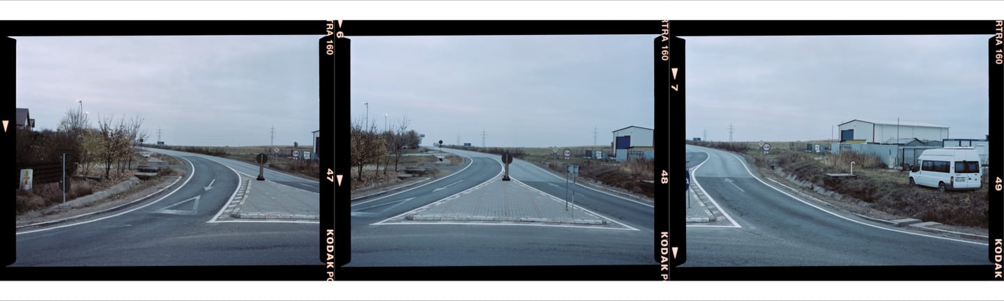 Composite photo overcast day, winding road curves gently. Blue buildings and a white van on the side
