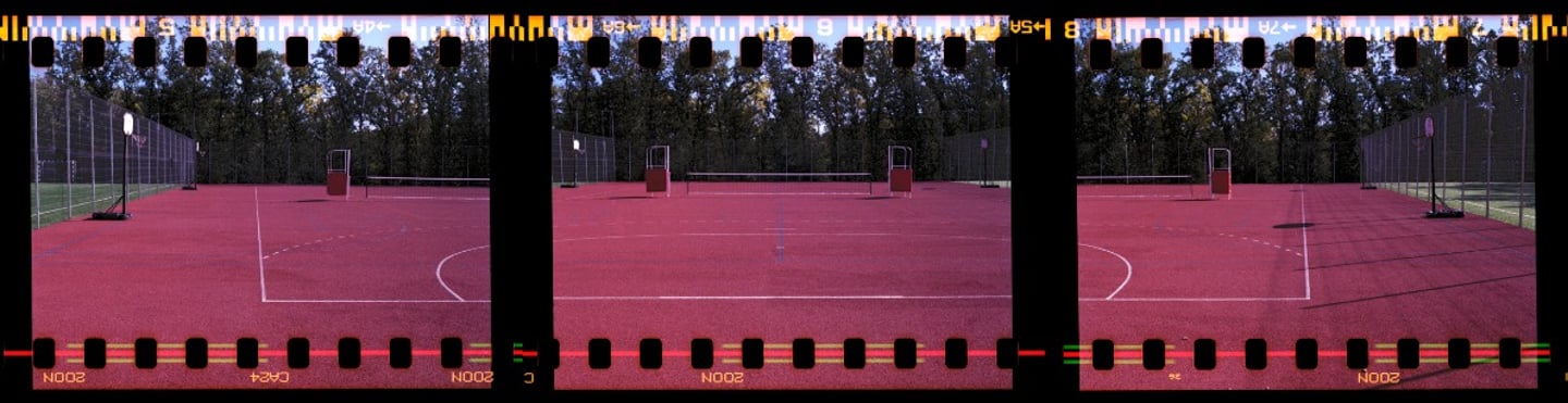 Composed photo of a vibrant red outdoor multipurpose sports court with crisp white markings
