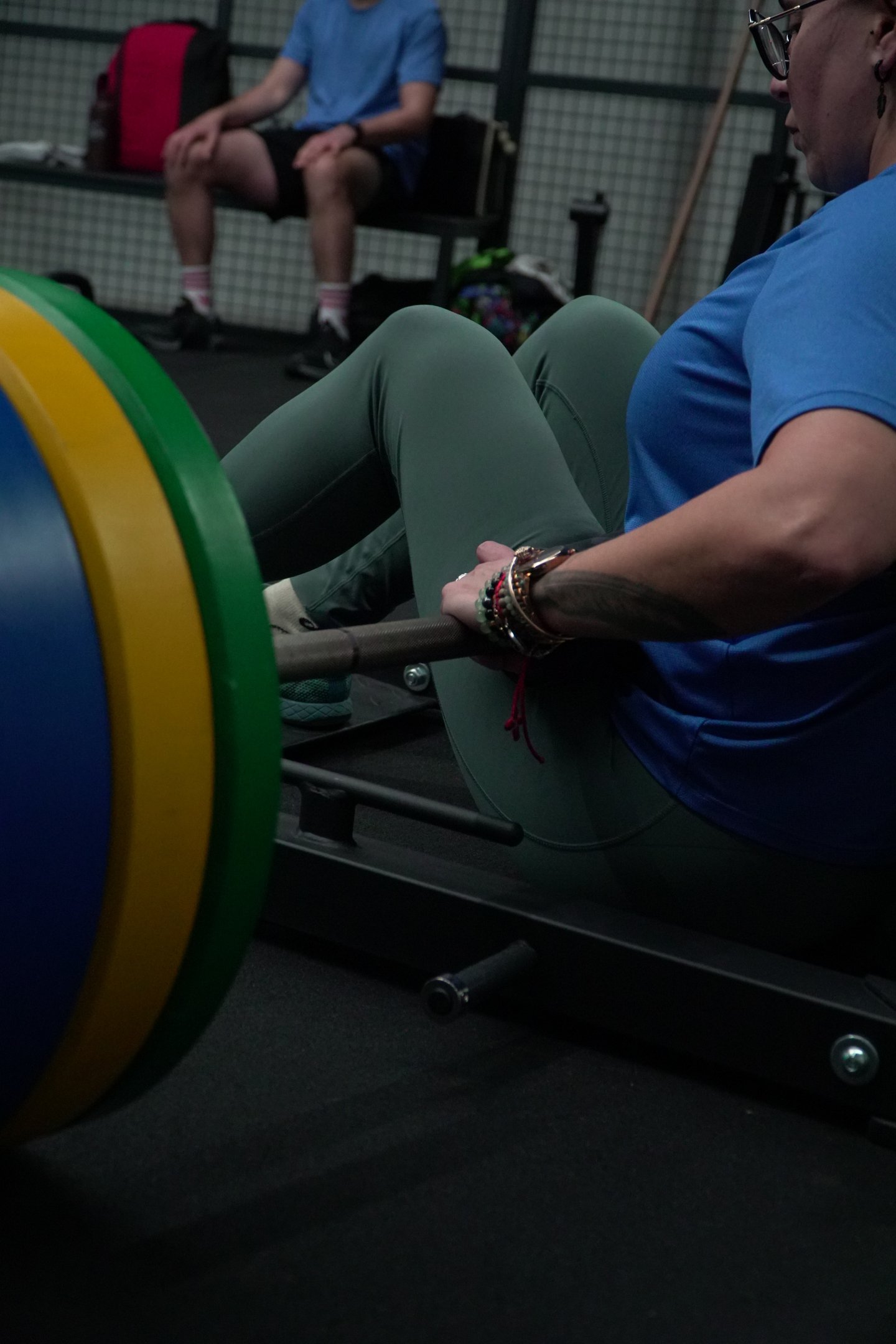 A woman performing a heavy barbell hip thrust exercise at the gym for glute strength.