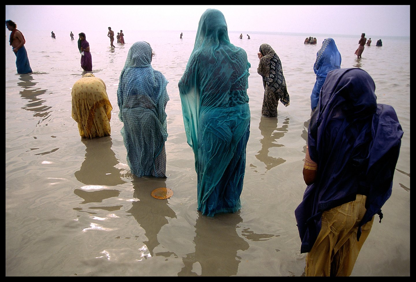 Spiritual pilgrims pray at the place where the Ganges River empties into the ocean.